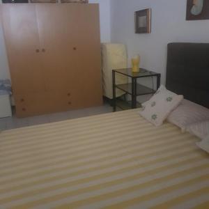 a bedroom with a bed and a cabinet and a table at CONDOMINIO CESANO MARE in Marotta