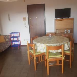 a dining room with a table and chairs and a television at CONDOMINIO CESANO MARE in Marotta