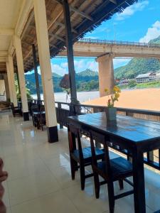 a table and chairs with a view of the ocean at Dormitory Hostel Cam Uo in Nongkhiaw +5 photos