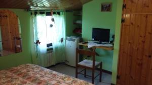 a bedroom with green walls and a desk with a computer at Villa Finetti in Gubbio