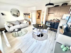 a kitchen and living room with a table and a couch at Vincenzo appart, Studio Confortable à Nendaz, accès Direct au Télécabine de Tracouet et Parking Souterrain Inclus in Nendaz