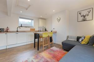 a kitchen and a living room with a couch at Stylish Bakewell apartment -walk to cafes and river in Bakewell +8 photos