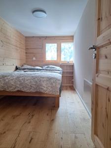 a bedroom with a bed and a wooden floor at Le cocon de Mâche in Hérémence