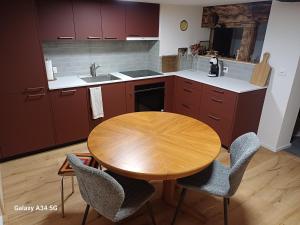 a kitchen with a wooden table and chairs at Le cocon de Mâche in Hérémence