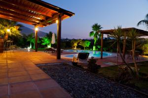 un patio con piscina por la noche en Finca Los Sueños, en Alhaurín el Grande