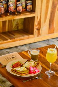 a plate of breakfast food and a glass of orange juice at Beda gaya ecolodge Rangsot 2 in Tanjung +16 photos