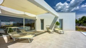a patio with chairs and a table on a patio at Villa Menta 4 by Villas Guide in Malinska