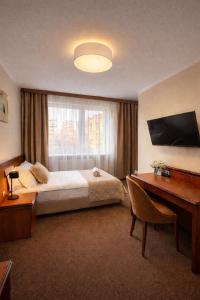 a bedroom with a bed and a desk and a window at Załęże in Katowice