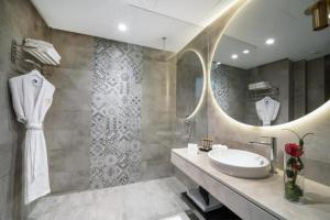 a bathroom with a sink and a mirror at Petit Palace Suites Hotel in Agadir +27 photos