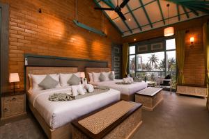 a bedroom with two beds and a brick wall at Hiriketiya Beach Resort in Hiriketiya +189 photos