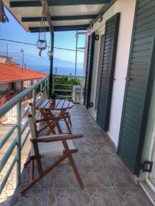 eine Terrasse mit Tisch und Stühlen auf einem Balkon in der Unterkunft Kasimiotis studio in Koroni
