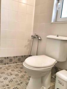 ein Badezimmer mit weißer Toilette und Fliesenboden in der Unterkunft Kasimiotis studio in Koroni + 13 Fotos