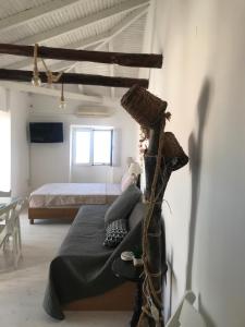 Ein Mann sitzt auf einem Bett in einem Schlafzimmer in der Unterkunft Kasimiotis studio in Koroni