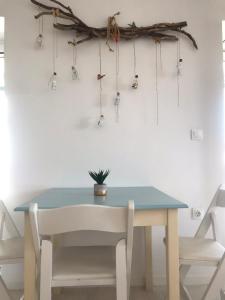 Ein Tisch und Stühle, ein blauer Tisch und Treibholz an der Wand in der Unterkunft Kasimiotis studio in Koroni