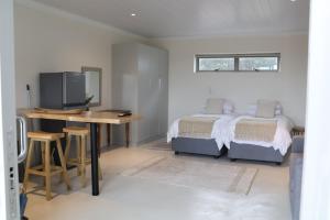 a bedroom with a bed and a desk and a tv at Sarah's Place -Stilbaai in Stilbaai