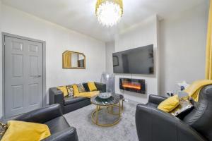a living room with couches and a fire place at Contractor-friendly Home in Stoke with Free Parking in Stoke on Trent