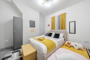 a bedroom with two beds with yellow and white at Contractor-friendly Home in Stoke with Free Parking in Stoke on Trent
