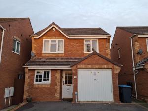 a brick house with a white garage at Family-run 5 Star Home - Consistent Superhosts in Long Lawford