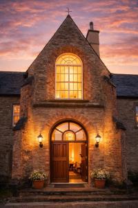 an old stone house with a large door at sunset at Barmeath Castle Guest House in Dún Léire
