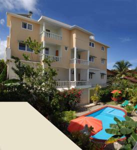 a villa with a swimming pool and a house at Aparthotel Michaela in Sosúa
