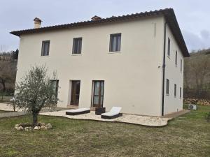 a white house with two benches in front of it at Il Podere Orto in San Gimignano