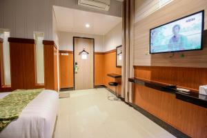 a hotel room with a flat screen tv on a wall at Akasia Budget Hotel in Ulujami