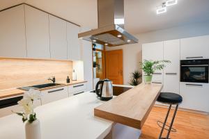 a kitchen with white cabinets and a wooden counter top at Green View Kamnik in Kamnik