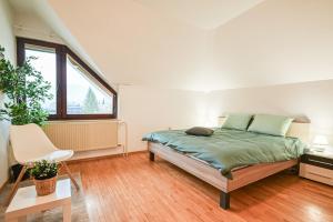 a bedroom with a bed and a chair in it at Green View Kamnik in Kamnik