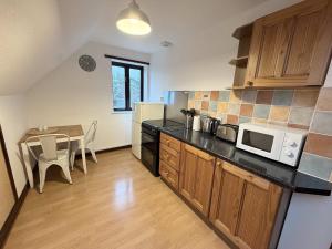 a kitchen with a table and a microwave at Millbrook House Apartments 7 in Milton