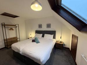 a bedroom with a large white bed with a window at Millbrook House Apartments 7 in Milton