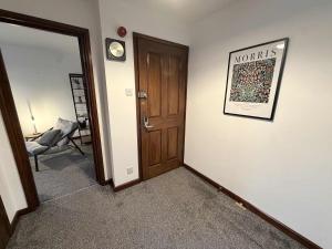 a hallway with a door and a chair in a room at Millbrook House Apartments 7 in Milton +11 photos