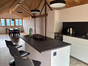 a kitchen with a counter and chairs and a table at Apartment Bärgli in Krattigen in Krattigen +11 photos