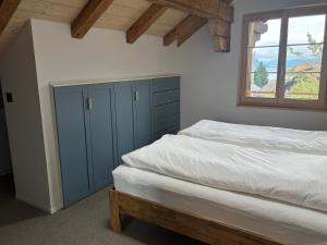 a bedroom with a blue cabinet and a bed at Apartment Bärgli in Krattigen in Krattigen