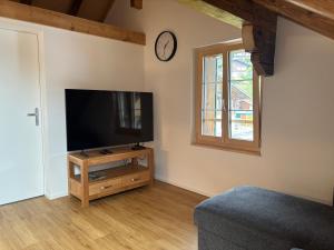 a living room with a flat screen tv and a window at Apartment Bärgli in Krattigen in Krattigen