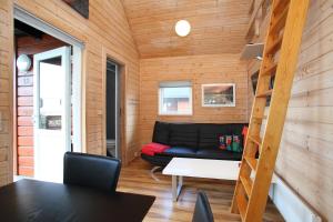 a living room with a black couch and a table at Hedebo Strand Camping in Sæby