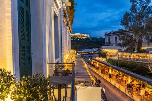 a balcony of a building with tables and chairs at Iliotropio Athens, Thisio in Athens