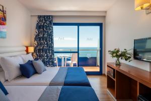 a bedroom with a bed with a view of the ocean at Hotel Tahití Playa & Suites 4Sup in Santa Susanna