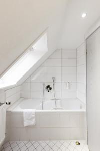 a white bathroom with a bath tub with a skylight at Eventlocation & Hotel Schloss Neuburg in Obrigheim +56 photos