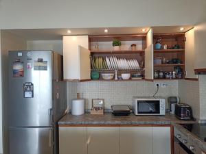 a kitchen with a refrigerator and a microwave at Seafront Family Apartment & free parking, the Cruiseflat in Thessaloniki +175 photos