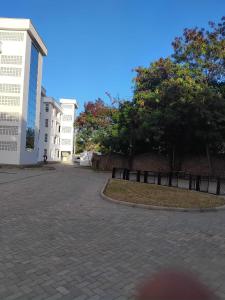 a cobblestone street with trees and a building at Mena apartment in Malindi