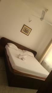 a bed with white sheets and pillows in a room at Mena apartment in Malindi +7 photos