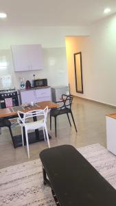 a living room with tables and chairs and a kitchen at Mena apartment in Malindi