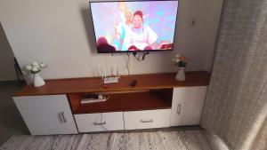 a flat screen tv on top of a entertainment center at Mena apartment in Malindi