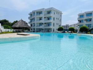 a large swimming pool in front of a building at Mena apartment in Malindi