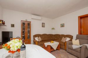 a living room with a couch and a table with a bottle of wine at Nika Vacation House in Zavojane