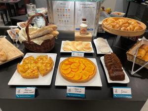 a counter with different types of bread and pies at Brit Hotel Belfort Centre-Le Boreal in Belfort +38 photos