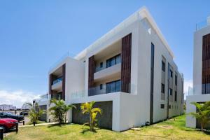 an exterior view of a white apartment building at Asmara Alora E3 - Beachfront in Rivière Noire +40 photos