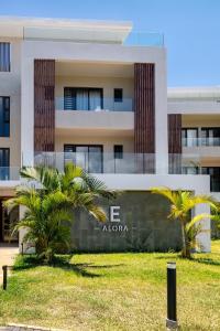 a building with palm trees in front of it at Asmara Alora E3 - Beachfront in Rivière Noire