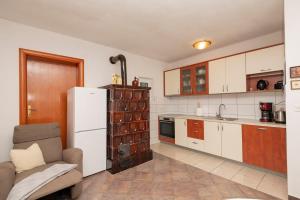 a kitchen with a refrigerator and a chair in it at Nika Vacation House in Zavojane