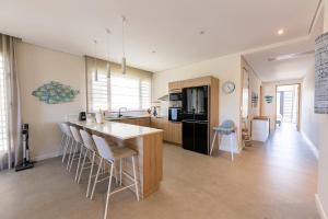 a kitchen with a island with bar stools at Asmara Alora E3 - Beachfront in Rivière Noire